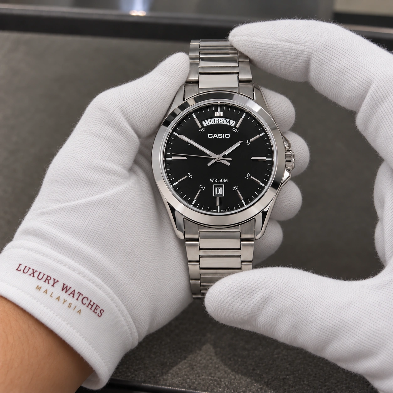 Casio MTP-1370D-1A1V presented in white gloves with a Luxury Watches Malaysia cuff mark