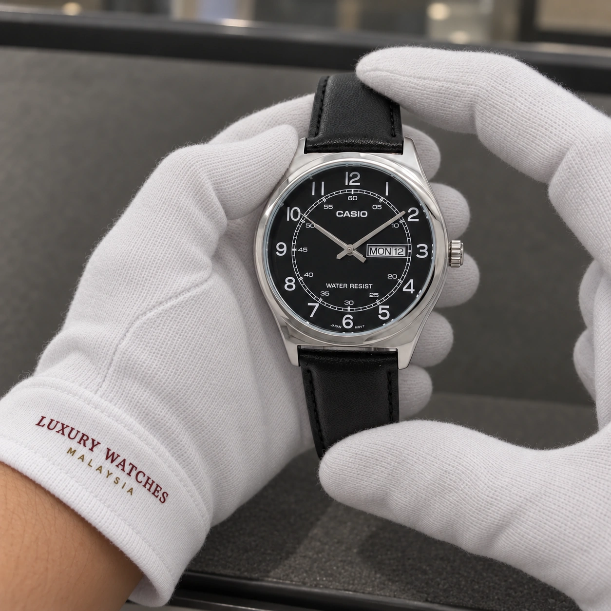 Casio MTP-V006L-1B2 presented in white gloves with a Luxury Watches Malaysia cuff mark