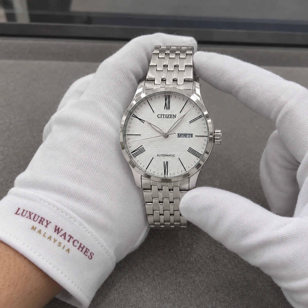 Citizen NH8350-59A presented in white gloves with a Luxury Watches Malaysia cuff mark