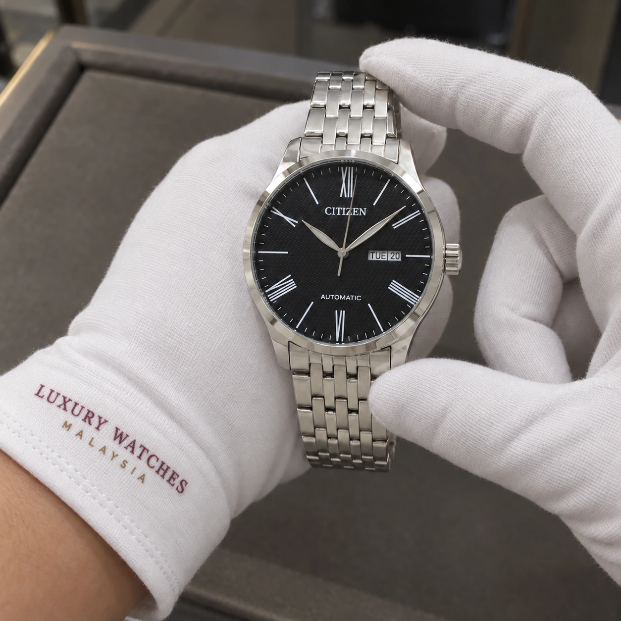 Citizen NH8350-59E presented in white gloves with a Luxury Watches Malaysia cuff mark