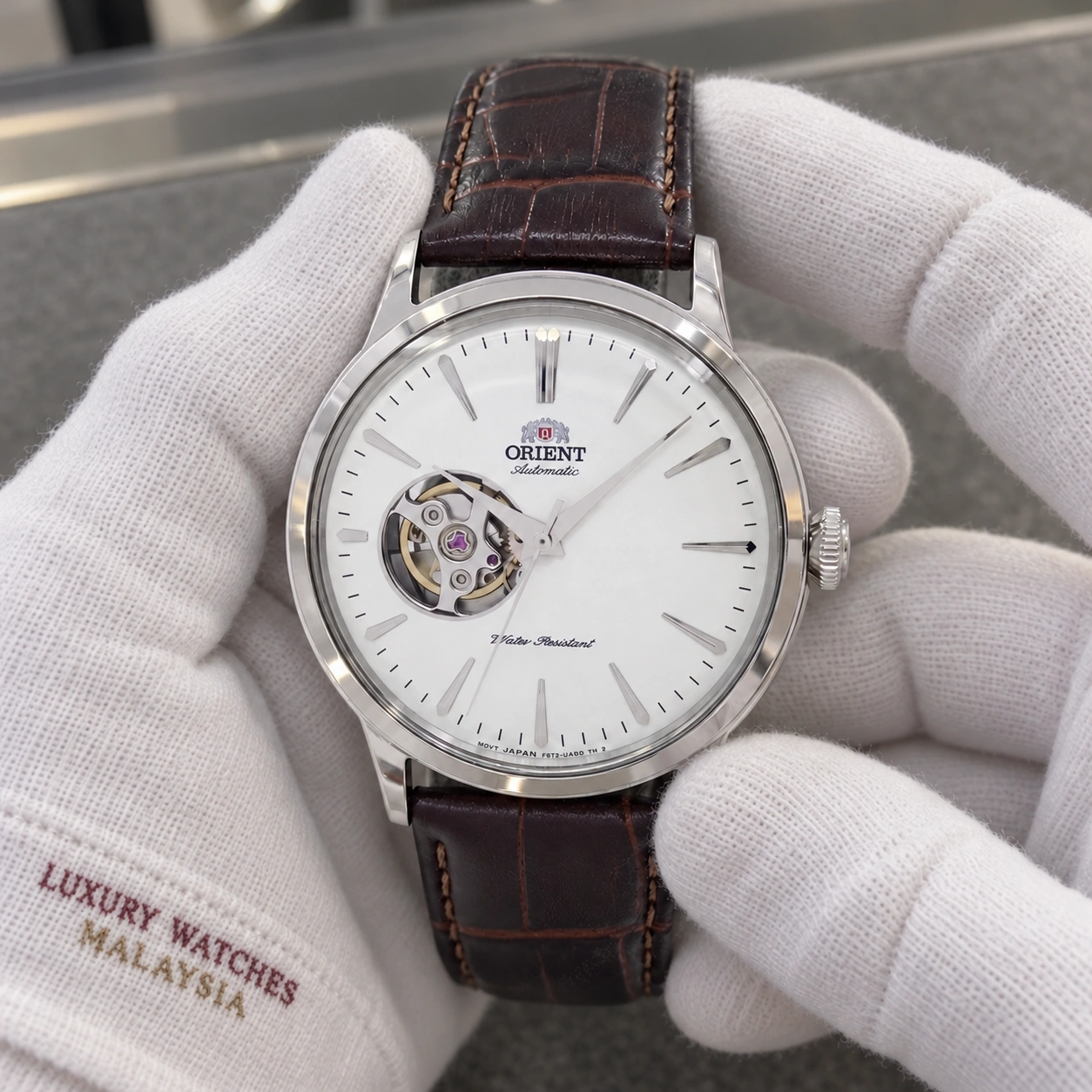 Orient RA-AG0002S10B presented in cotton gloves