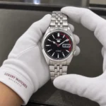 Seiko SNK375K1 held in white cotton gloves with Luxury Watches Malaysia cuff mark