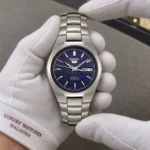 Seiko SNK603K1 held in white cotton gloves with Luxury Watches Malaysia cuff mark