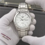 Seiko SNKK87K1 held in white cotton gloves with Luxury Watches Malaysia cuff mark