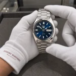 Seiko SNXS77K1 held in white cotton gloves with Luxury Watches Malaysia cuff mark