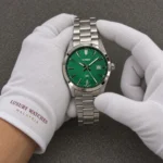 Casio Standard Analog Stainless Steel Green Dial Quartz MTP-VD03D-3A1 Men's Watch presented by cotton-gloved hands with wrist-cuff branding